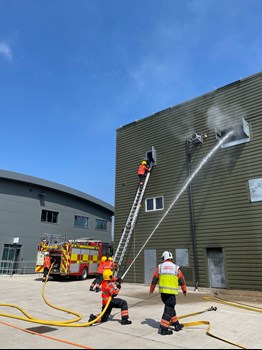 Wholetime firefighters carrying out a drill to celebrate finishing their training course